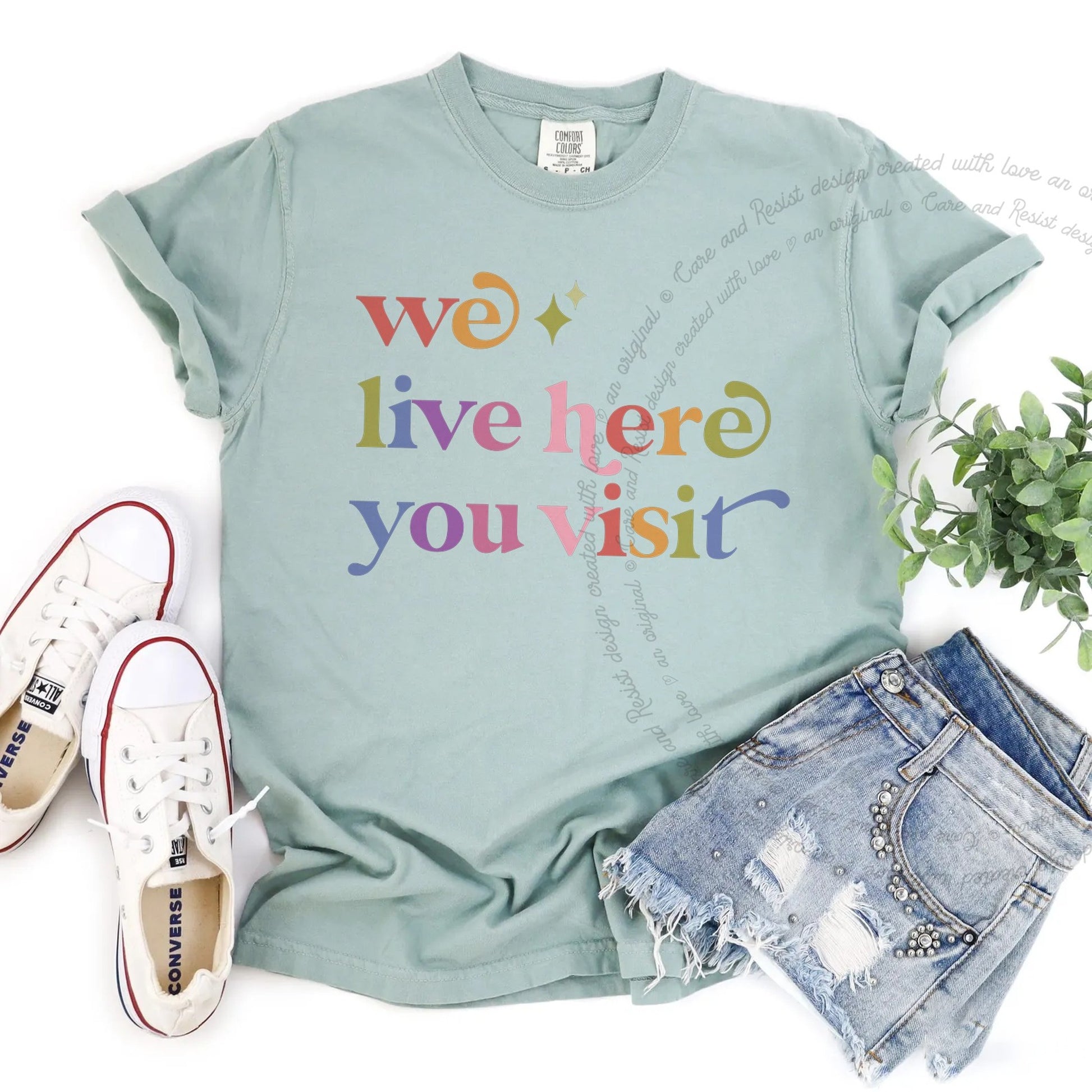 We Live Here You Visit Care & Resist rainbow tee