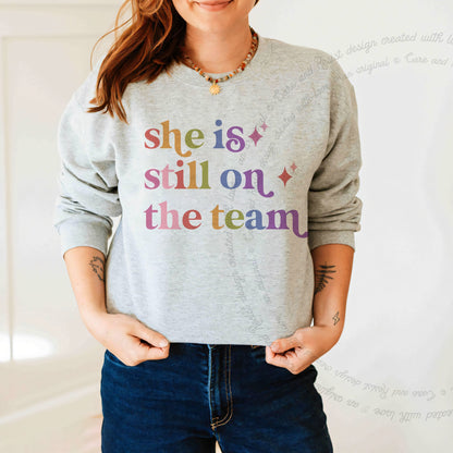 She is Still on the Team Care & Resist Gildan crewneck sweatshirt in Sport Grey