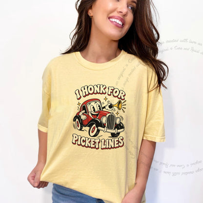 I Honk for Picket Lines Cartoon Care & Resist progressive t-shirt in Banana