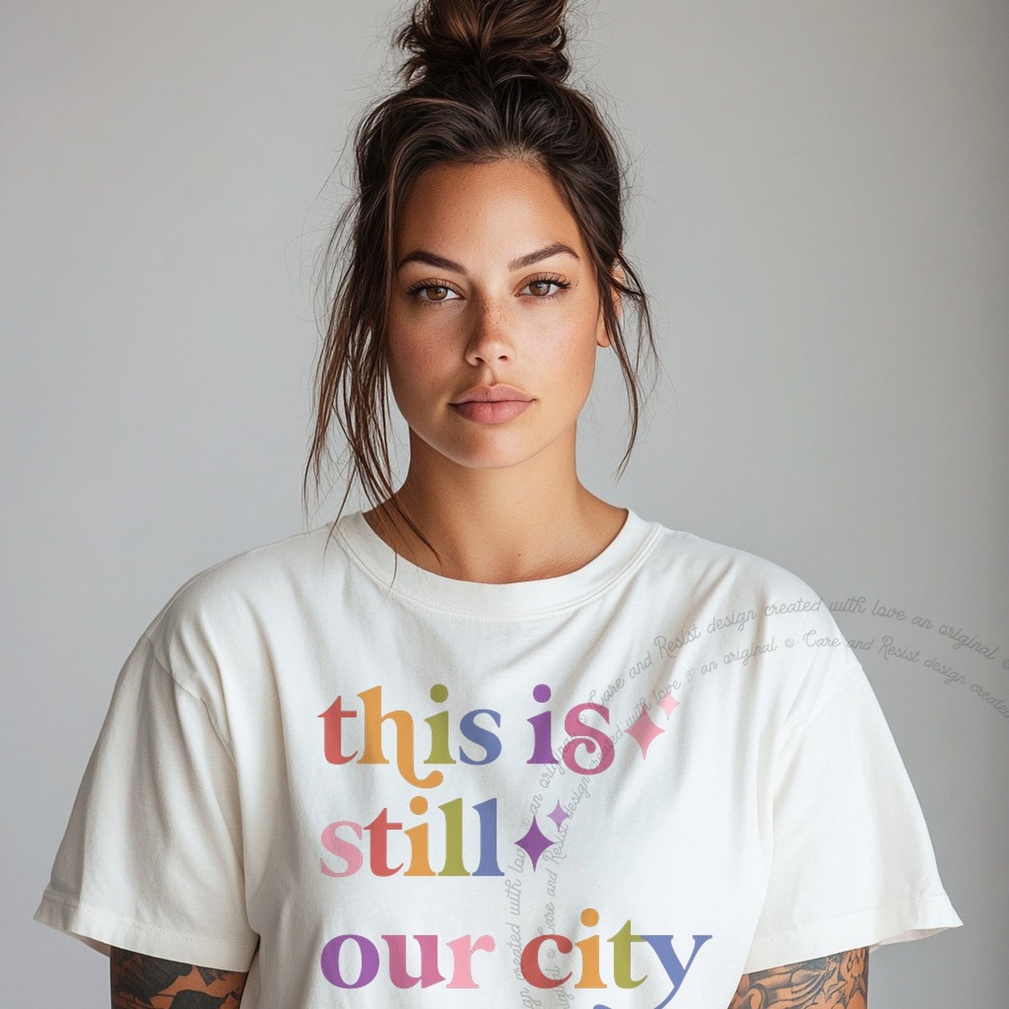 This is Still Our City Care & Resist rainbow tee