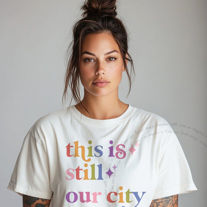 This is Still Our City Care & Resist rainbow tee