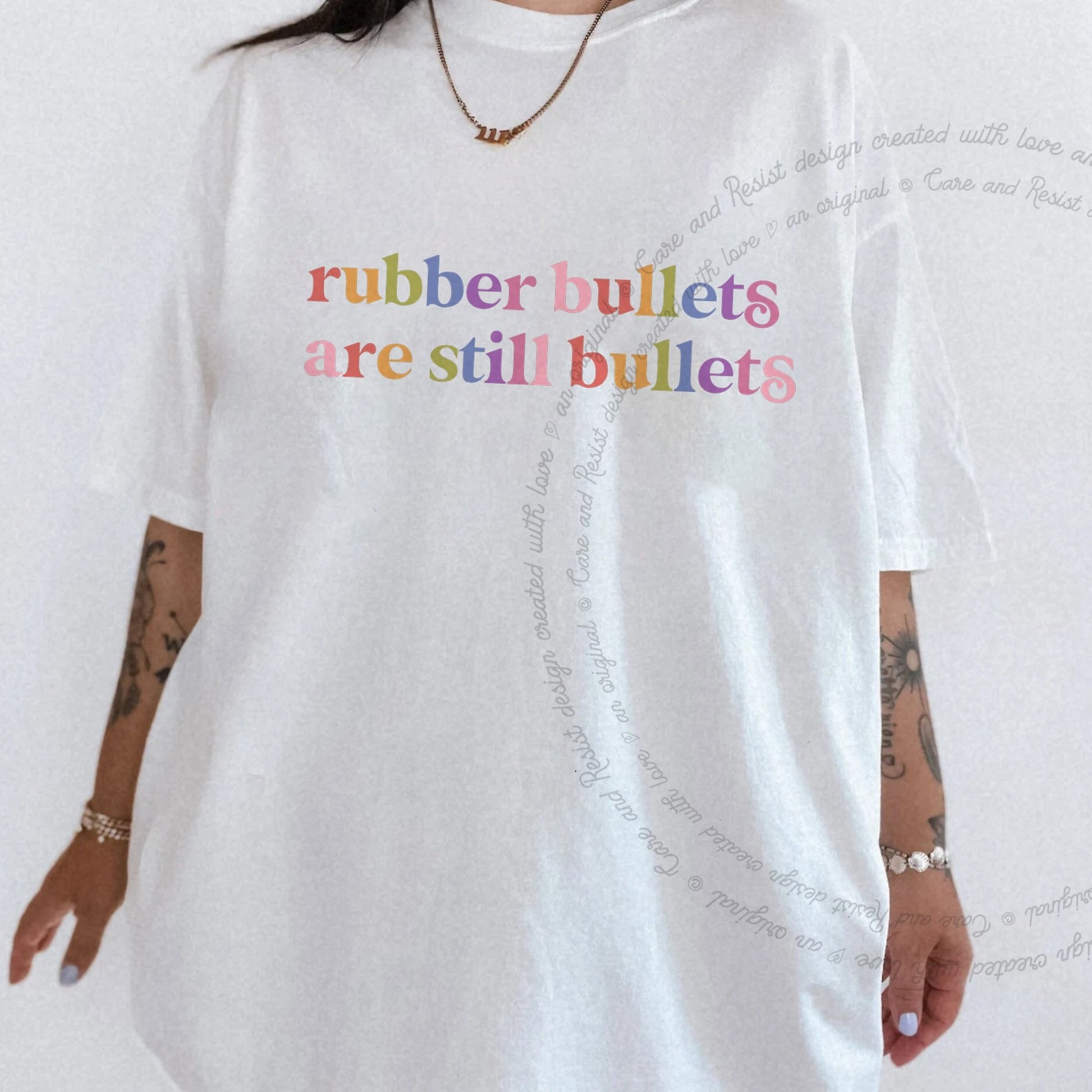 Rubber Bullets are Still Bullets Care & Resist rainbow Comfort Colors tee, White