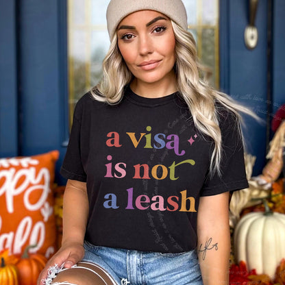 A Visa is not a Leash Care & Resist rainbow Comfort Colors tee, Black