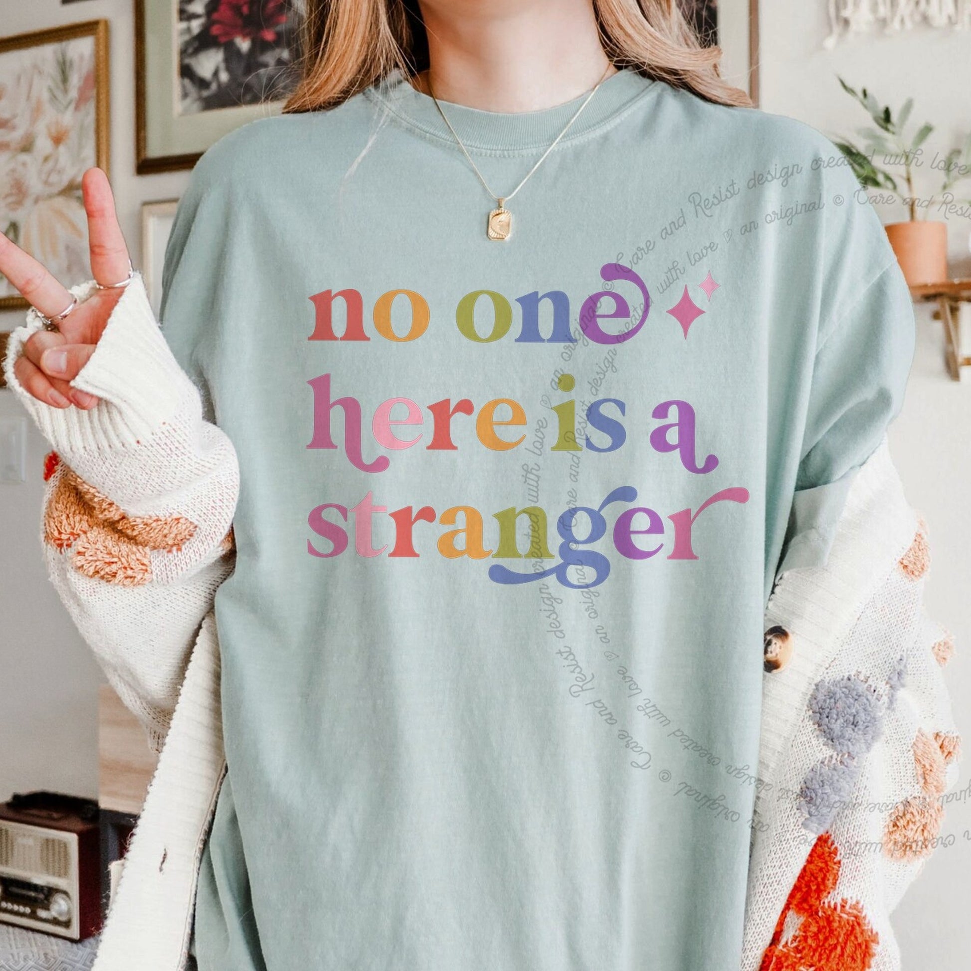 No One Here is a Stranger Care & Resist rainbow tee