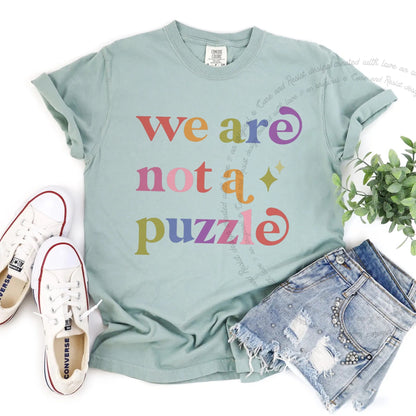 We are not a Puzzle Care & Resist rainbow tee