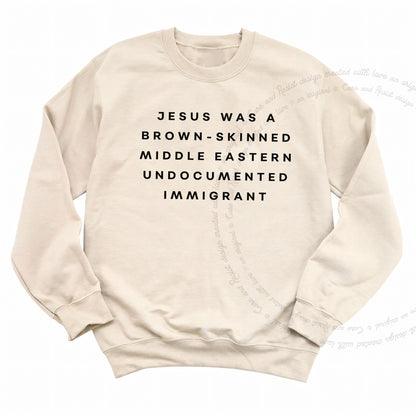 Jesus Was a Brownskinned Middle Eastern Undocumented Immigrant Care & Resist Gildan crewneck sweatshirt in Sand
