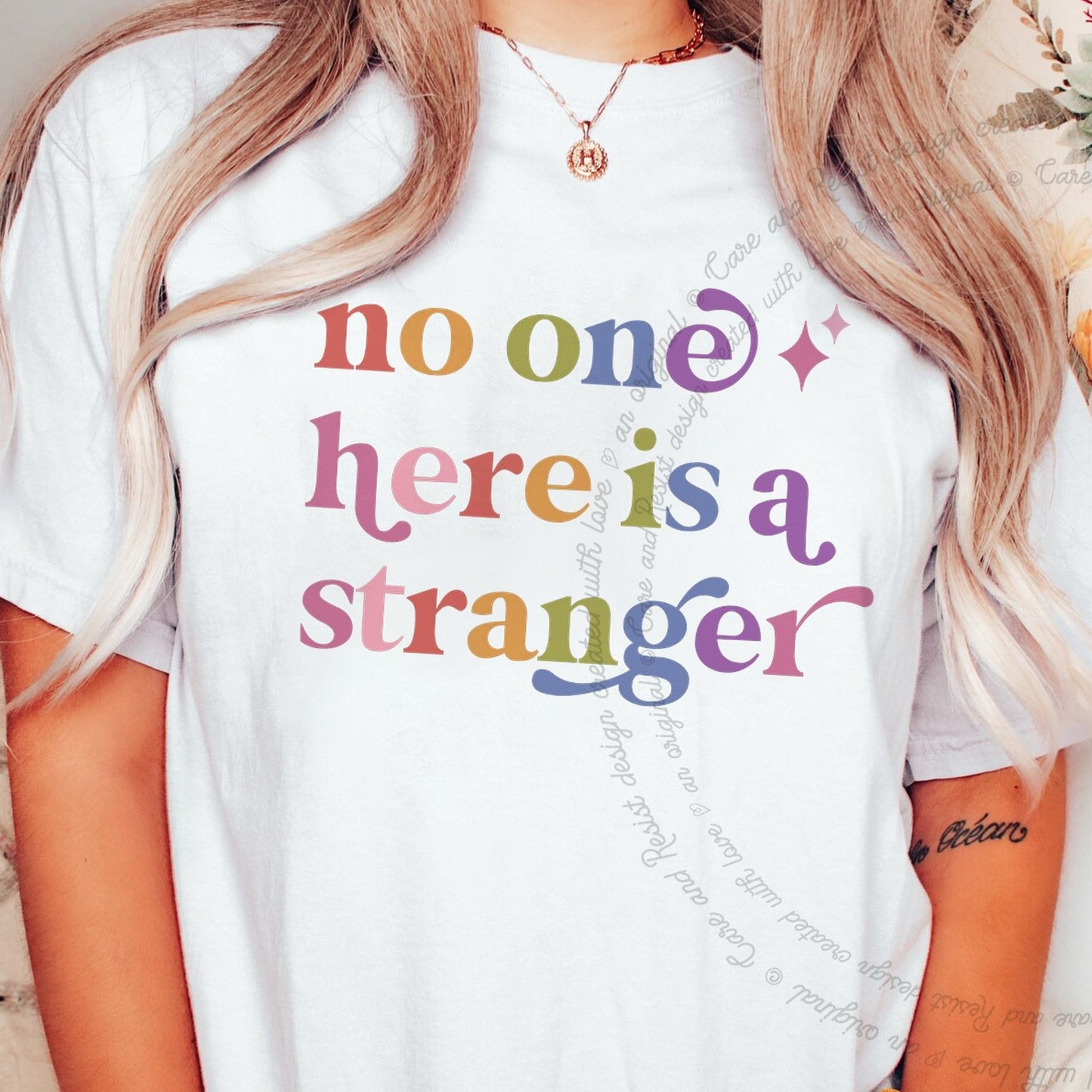 No One Here is a Stranger Care & Resist rainbow tee