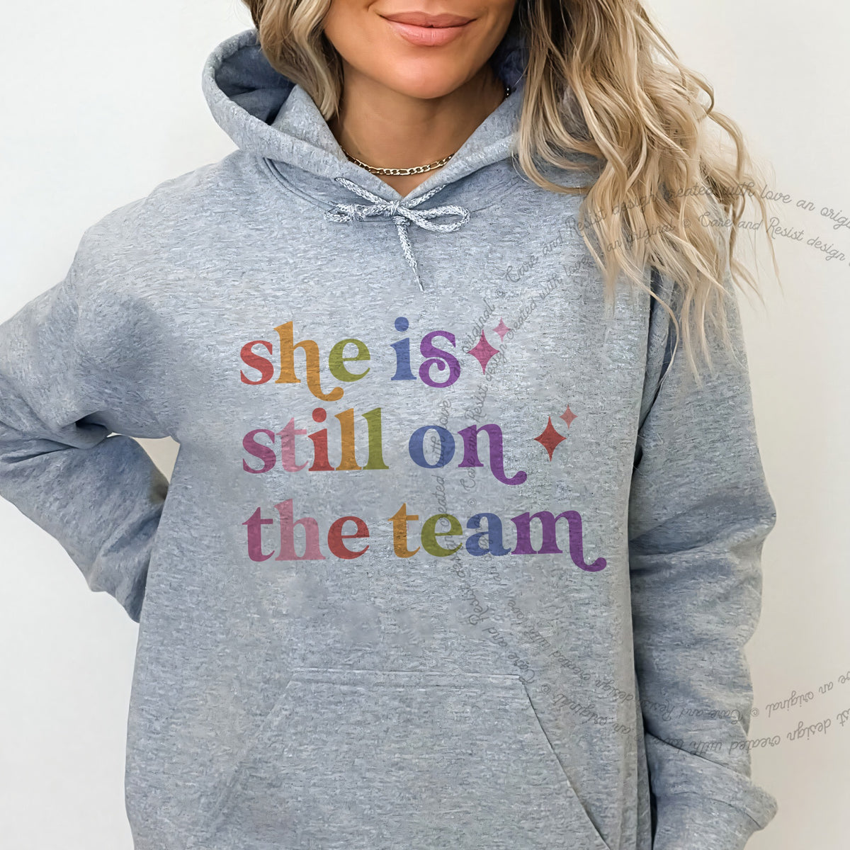 She is Still on the Team Care & Resist Gildan hoodie in Sport Grey