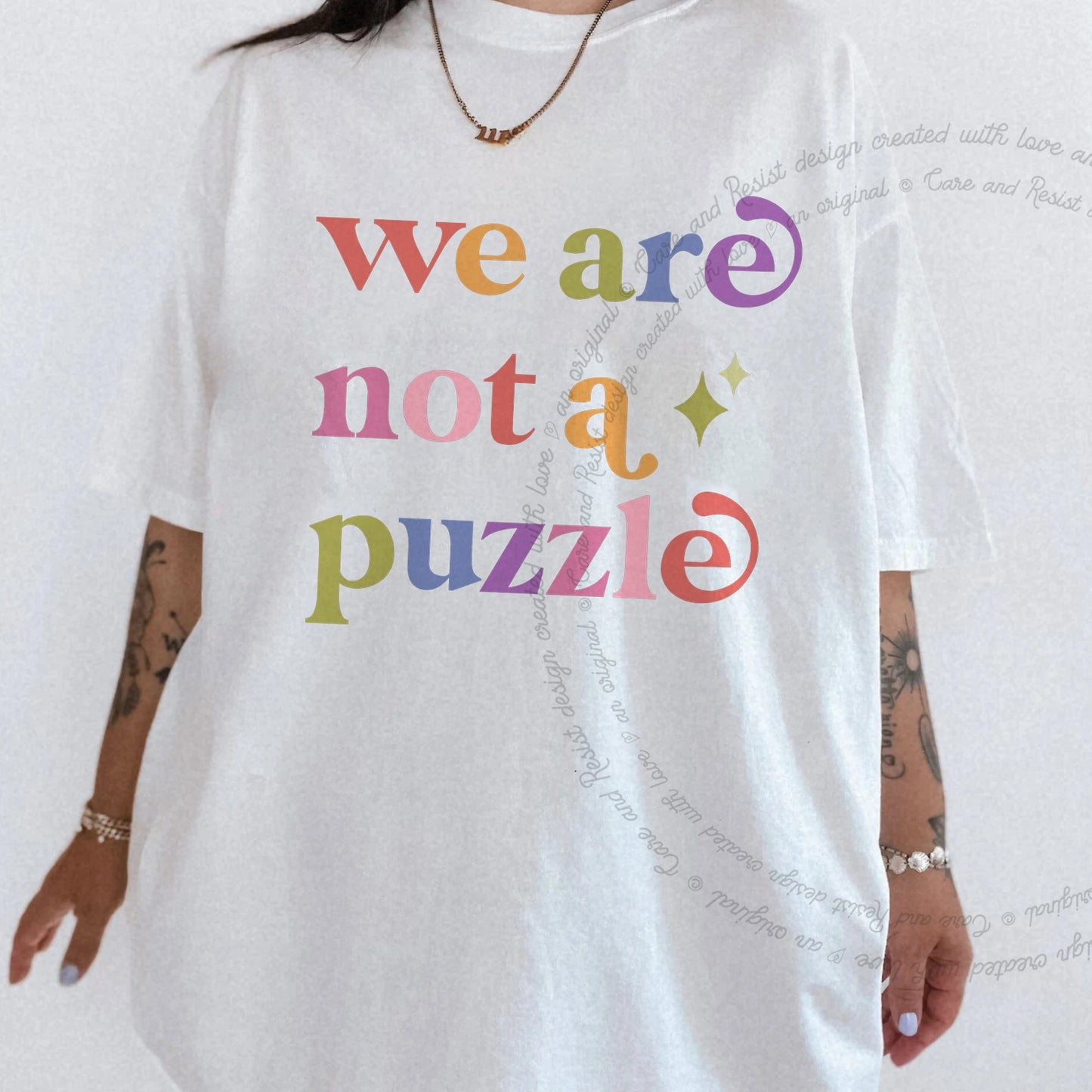 We are not a Puzzle Care & Resist rainbow tee