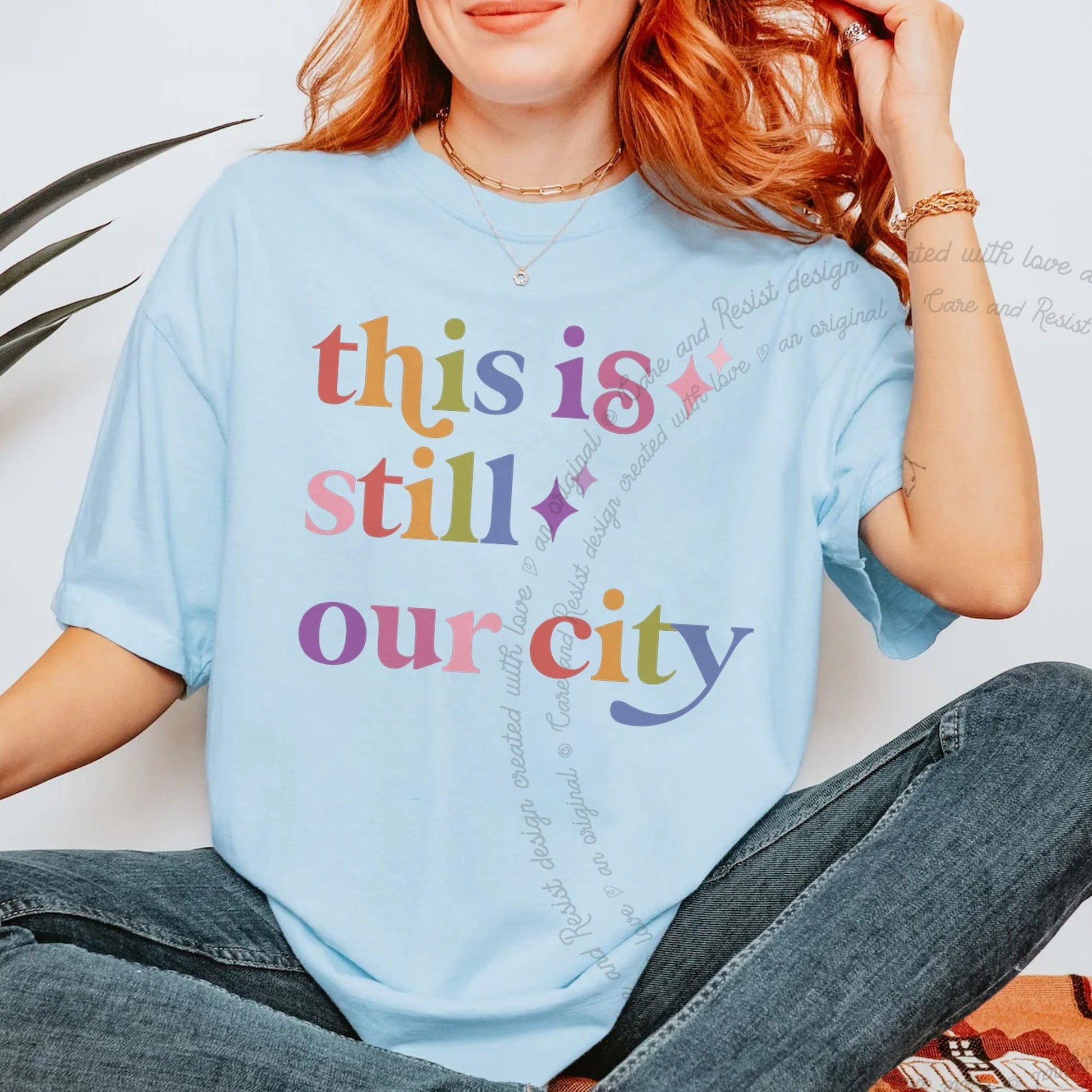 This is Still Our City Care & Resist rainbow tee
