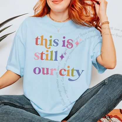 This is Still Our City Care & Resist rainbow tee