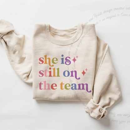 She is Still on the Team Care & Resist Gildan crewneck sweatshirt in Sand
