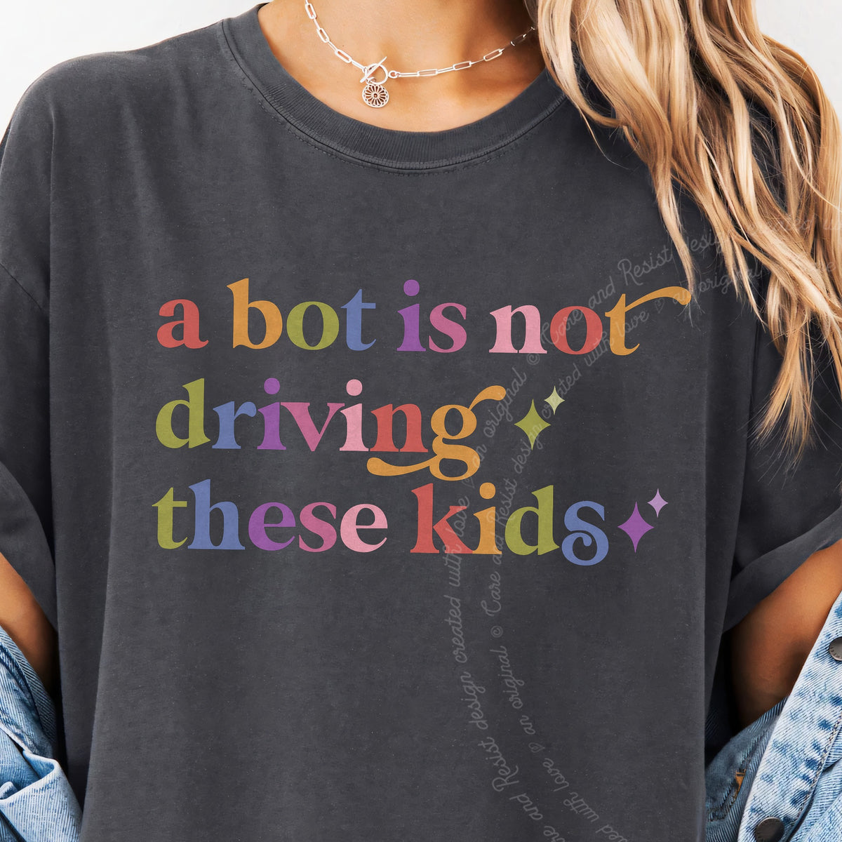A Bot is not Driving These Kids Care & Resist tee in Graphite, close-up of the lettering