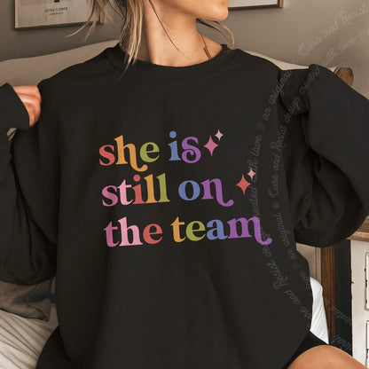 She is Still on the Team Care & Resist Gildan crewneck sweatshirt in Black